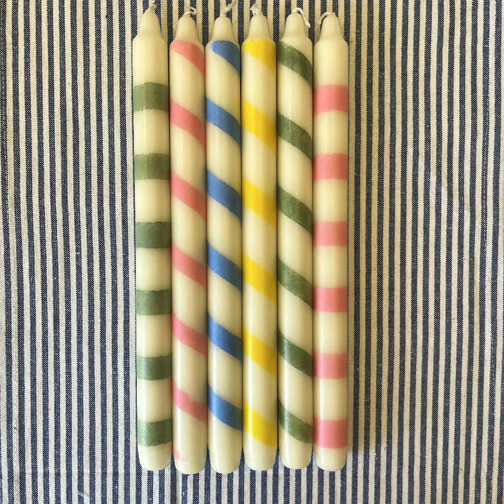 Handpainted ivory candles featuring playful stripes and twists